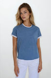 Woman wearing a blue t-shirt with white trim against a white background