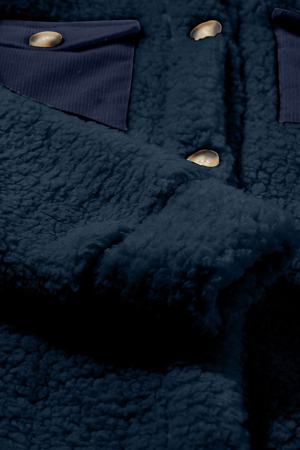 Close-up of a dark blue textured fabric with buttons.