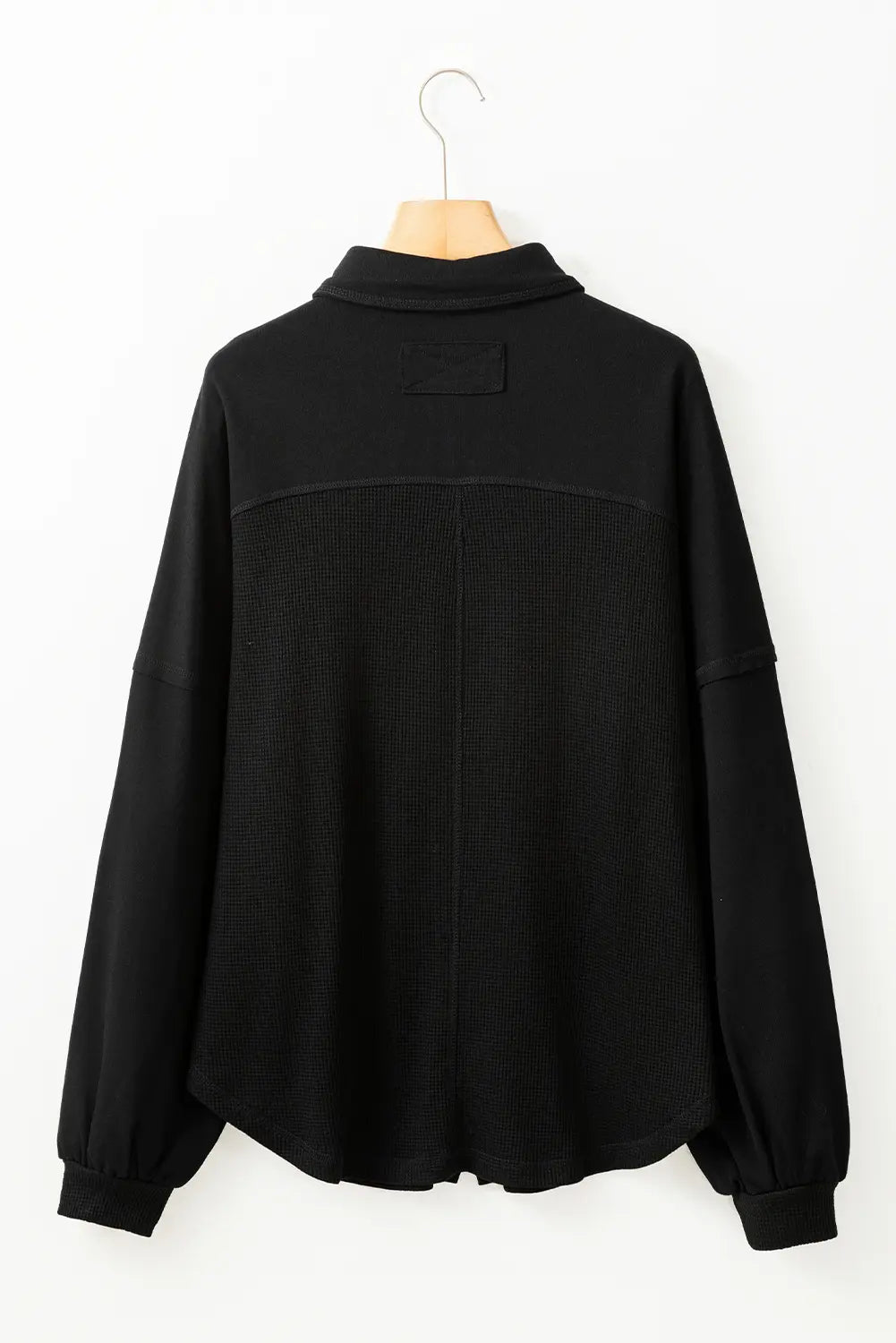 Black jacket on a hanger against a white background