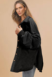 Woman wearing a black button-up shirt against a beige background