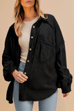 Person wearing a black jacket over a white shirt with a beige background