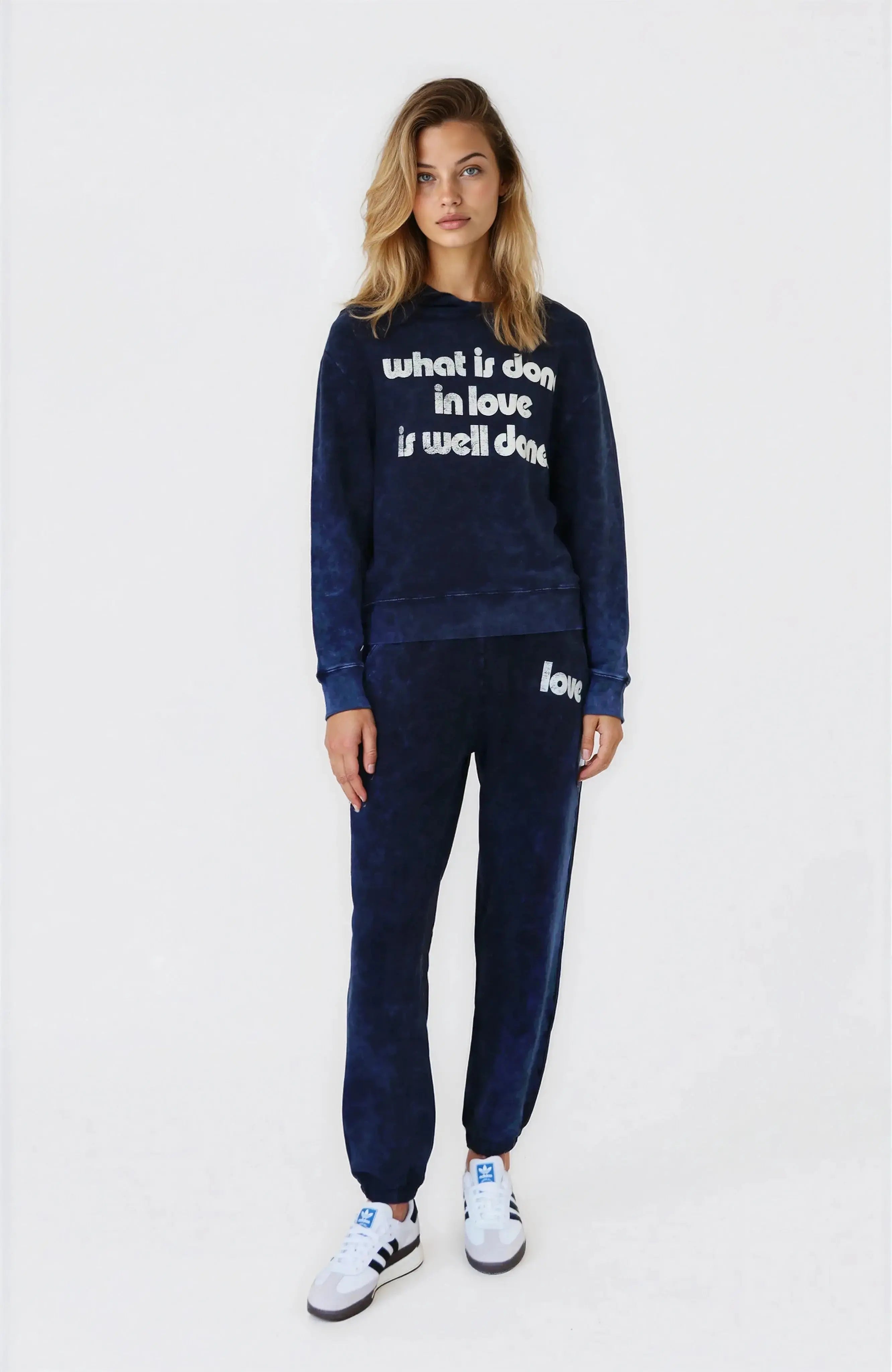 Woman wearing a navy tracksuit with text on a white background