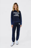 Woman wearing a navy tracksuit with text on a white background