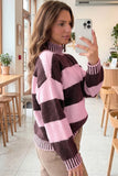 A woman takes a mirror selfie in a cafe while wearing a fuzzy knit mock-neck sweater with large pink and dark brown blocks.