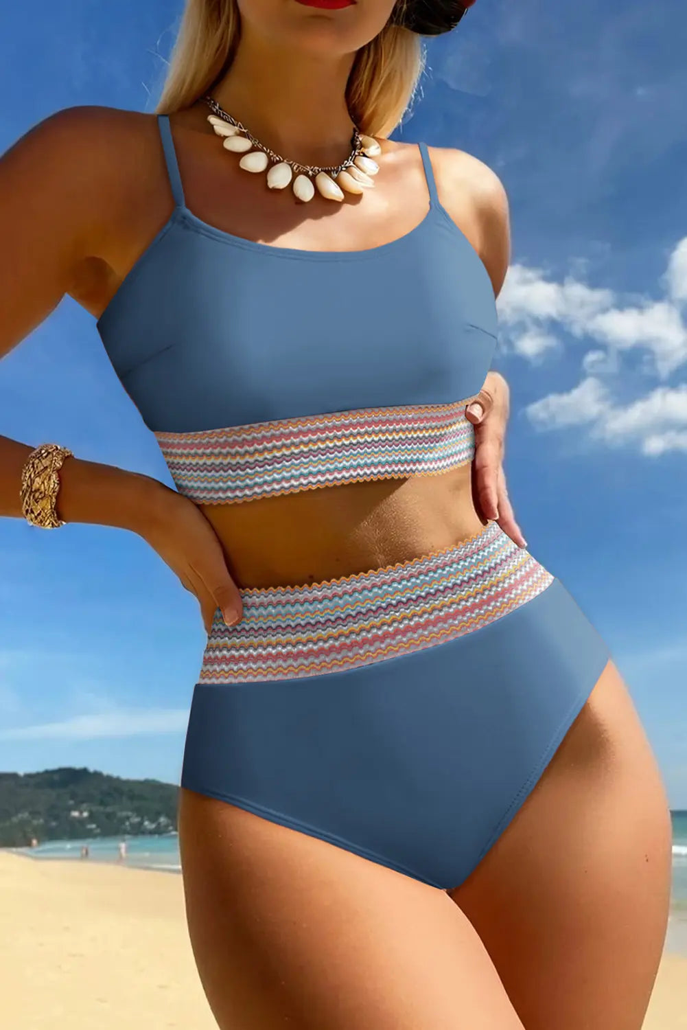 Woman in a blue bikini with a striped bottom on a beach