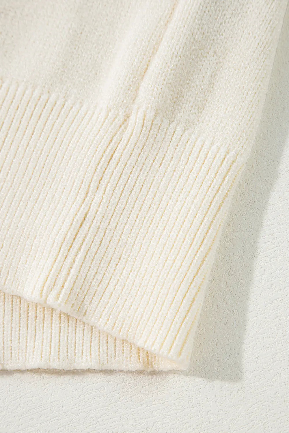 Close-up of a cream-colored sweater with ribbed texture