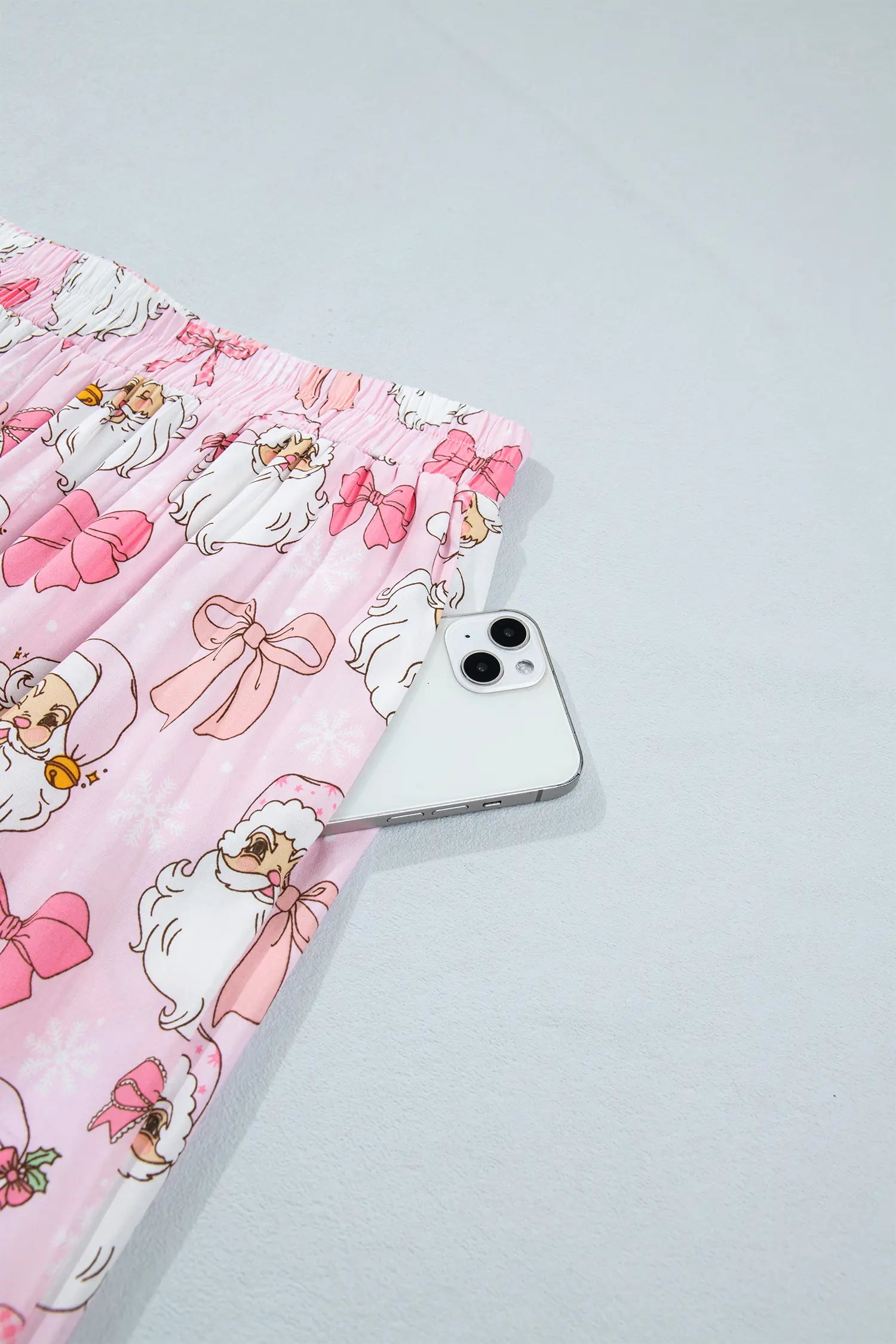 Pink pleated fabric with cartoon bunny print and white smartphone.