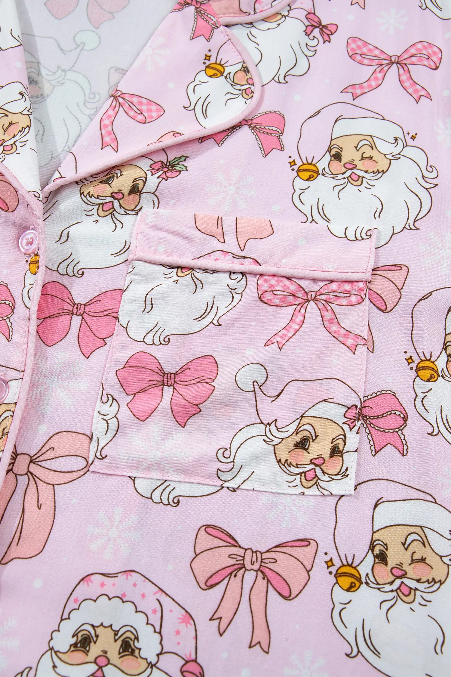 Pink pajama top with Santa and bow print, collar, buttons, and chest pocket.