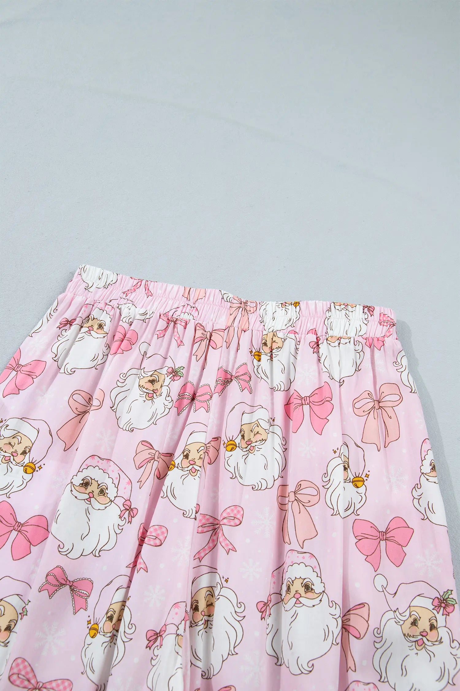 Pink pleated fabric with all-over cartoon Santa Claus print.