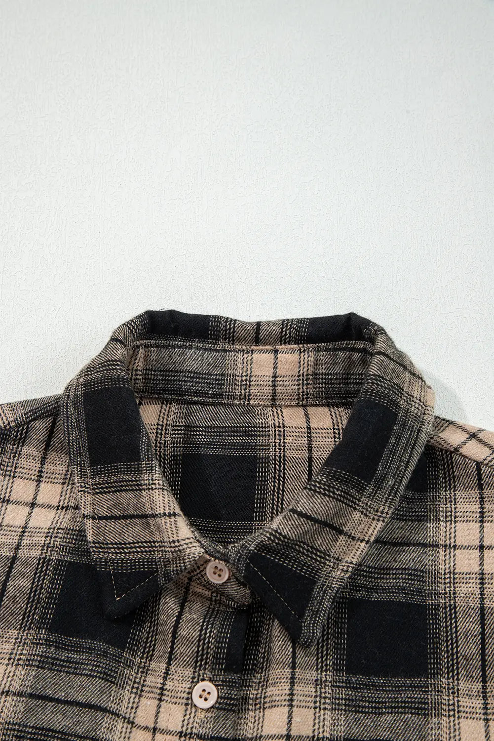 Plaid shirt with black accents on a light gray background