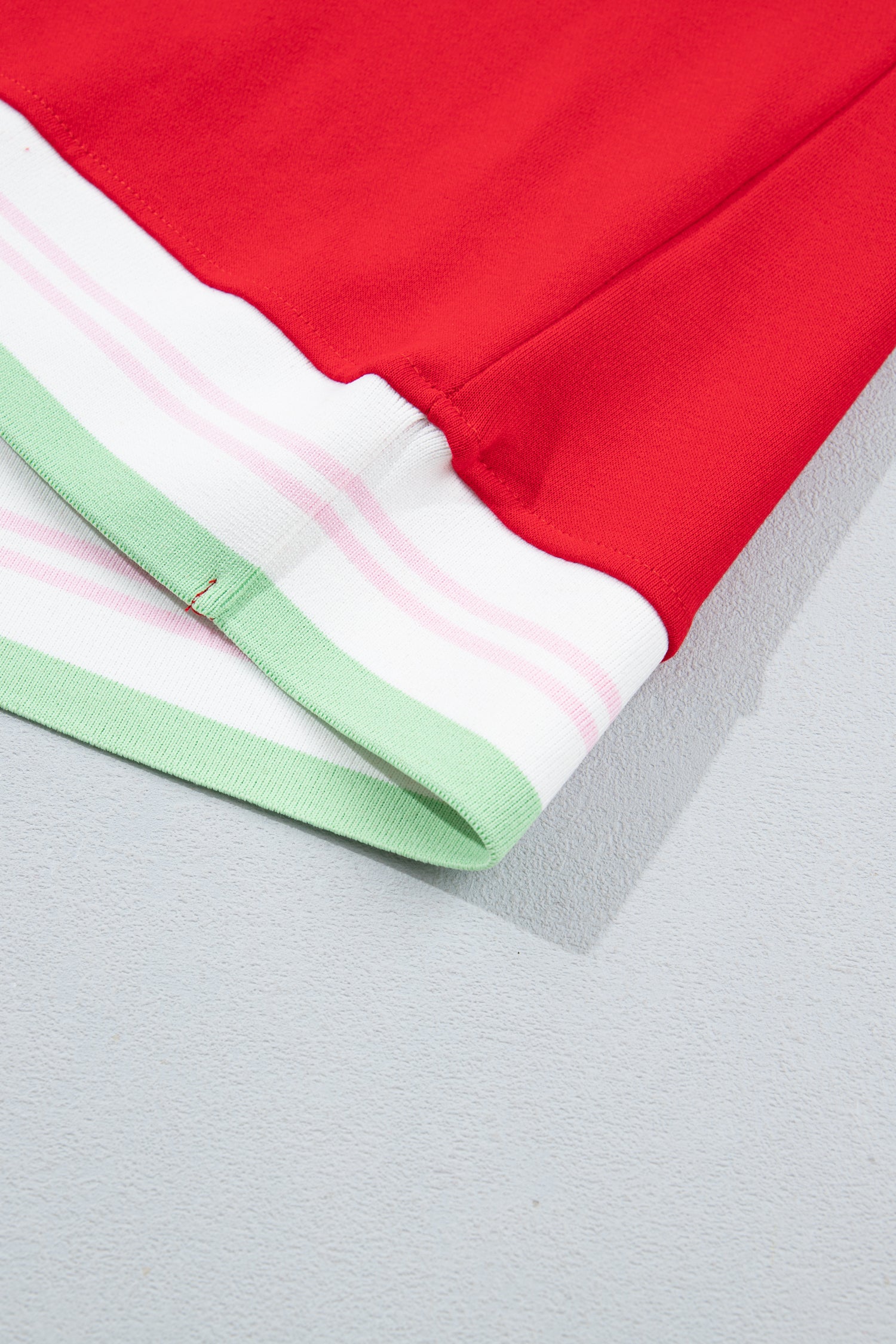 Close-up of a red garment corner with a white striped hemband