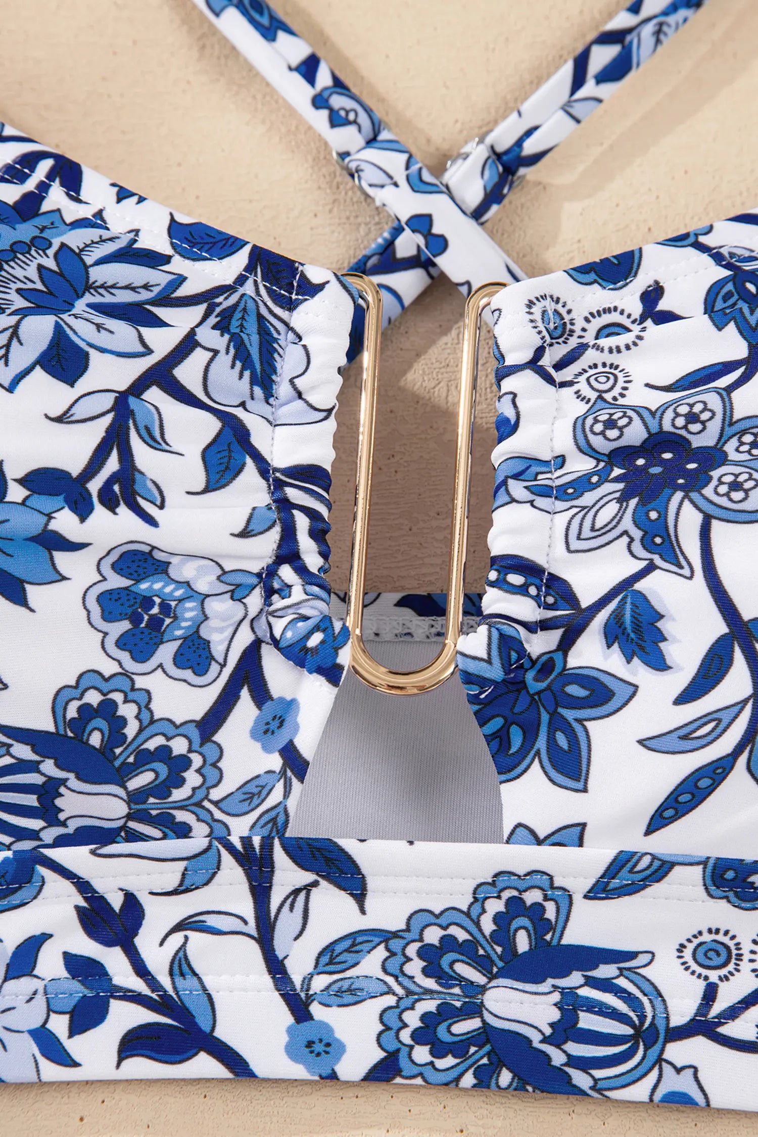 Close-up of a blue and white floral patterned bag with a gold buckle.