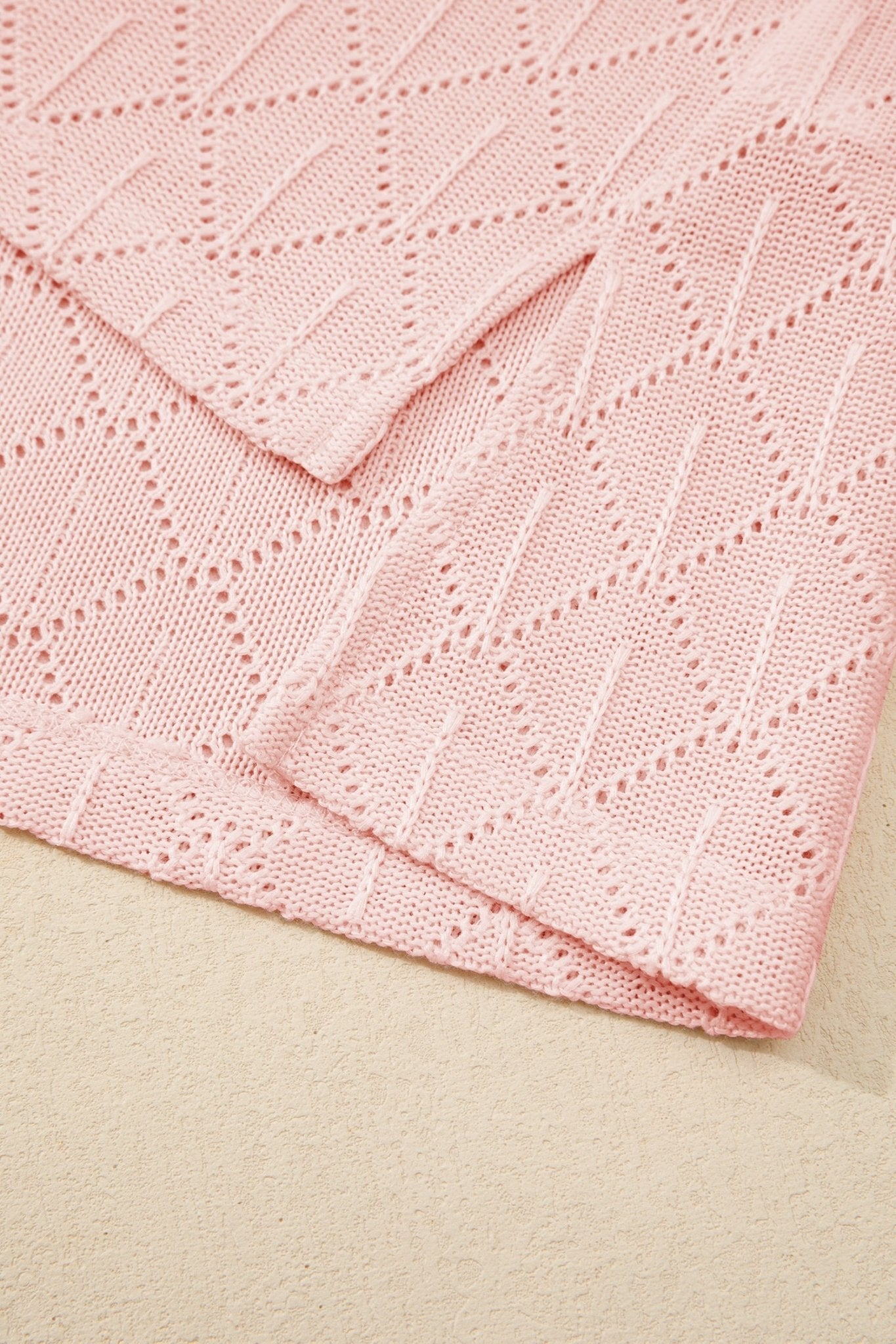 Close-up of a pink textured fabric on a beige surface
