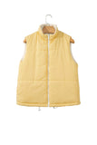 Pale yellow sleeveless puffer vest with white zipper and lining hanging on a wooden hanger.