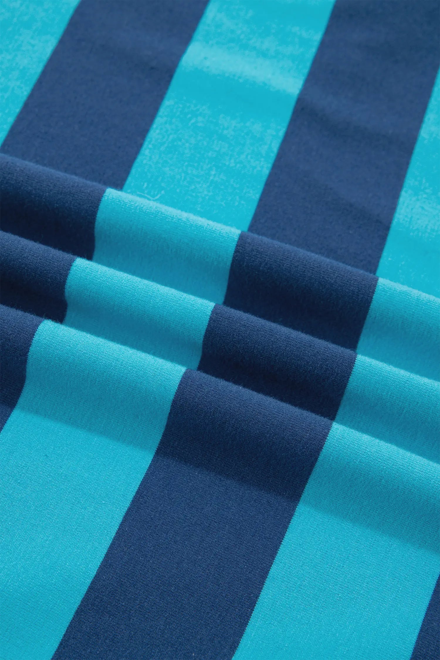 Close-up of soft navy and bright turquoise striped fabric with folds.
