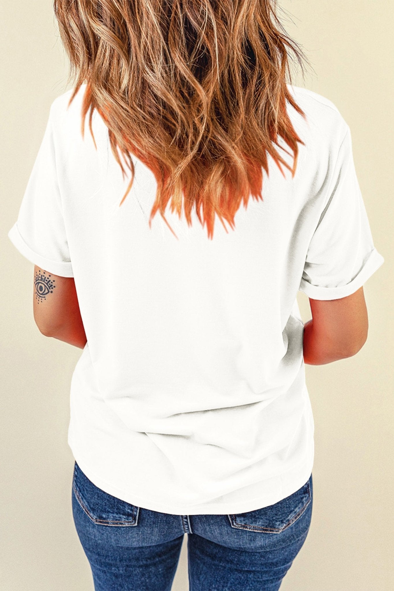 Person wearing a white t-shirt and blue jeans with a neutral background