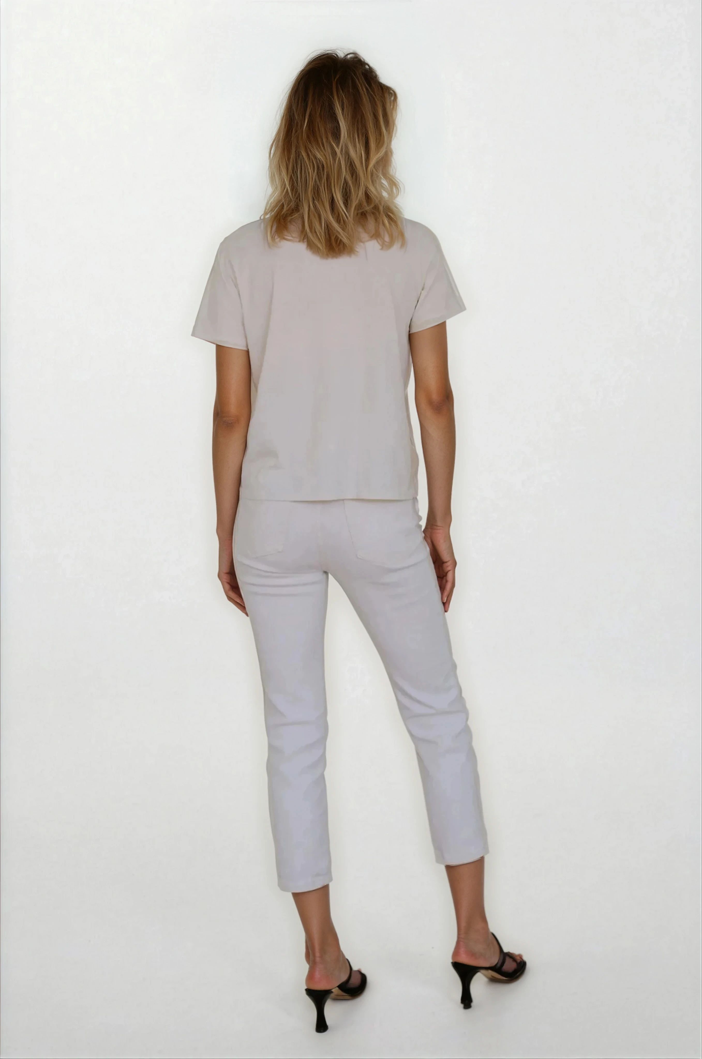 Person wearing a light gray outfit on a white background