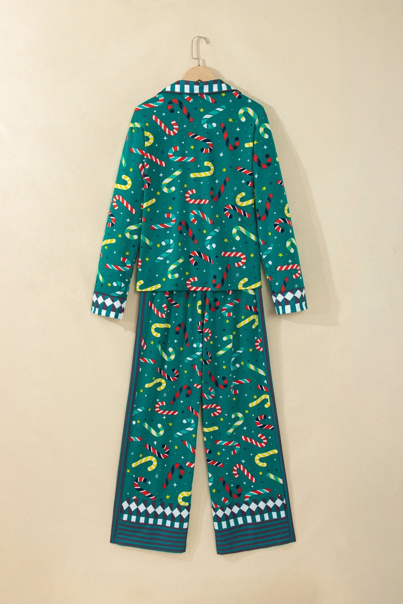Teal green holiday pajamas with red-yellow-white candy cane print on hanger.