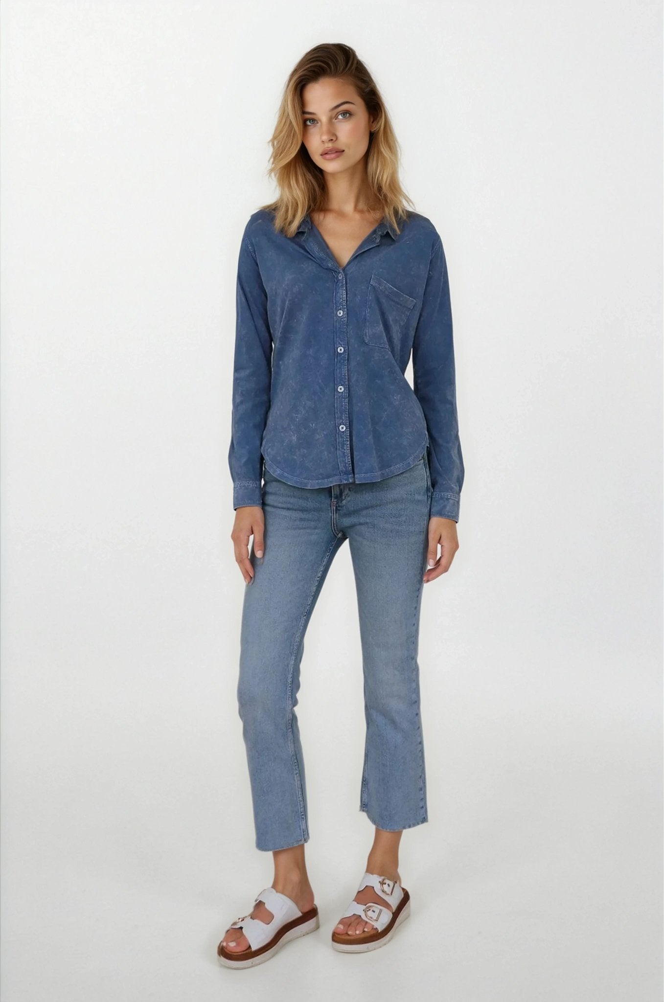 Woman wearing a blue shirt and jeans on a white background