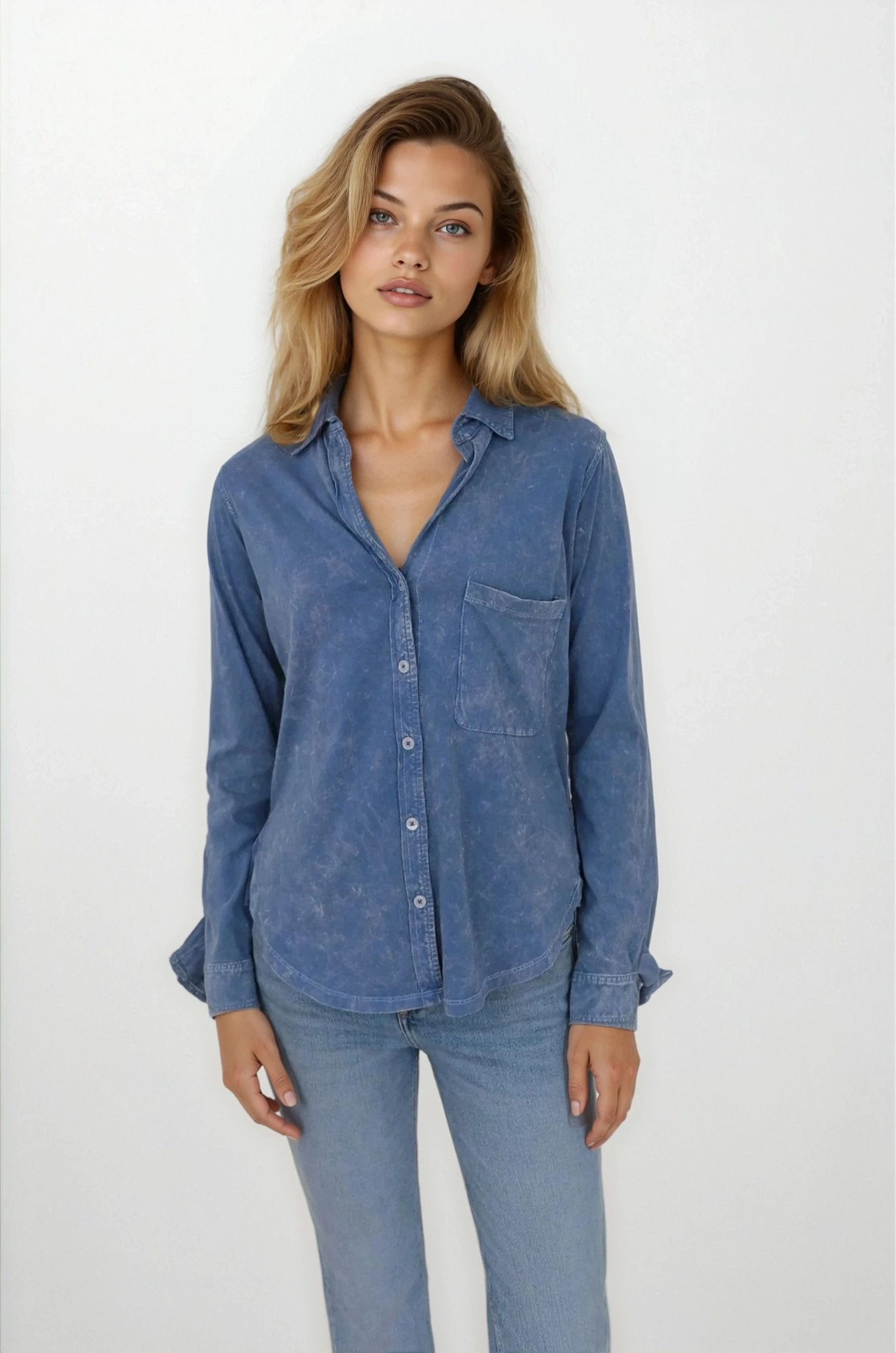 Woman wearing a blue denim shirt and jeans on a white background