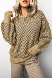 Person wearing a beige patterned sweater and pants against a white background