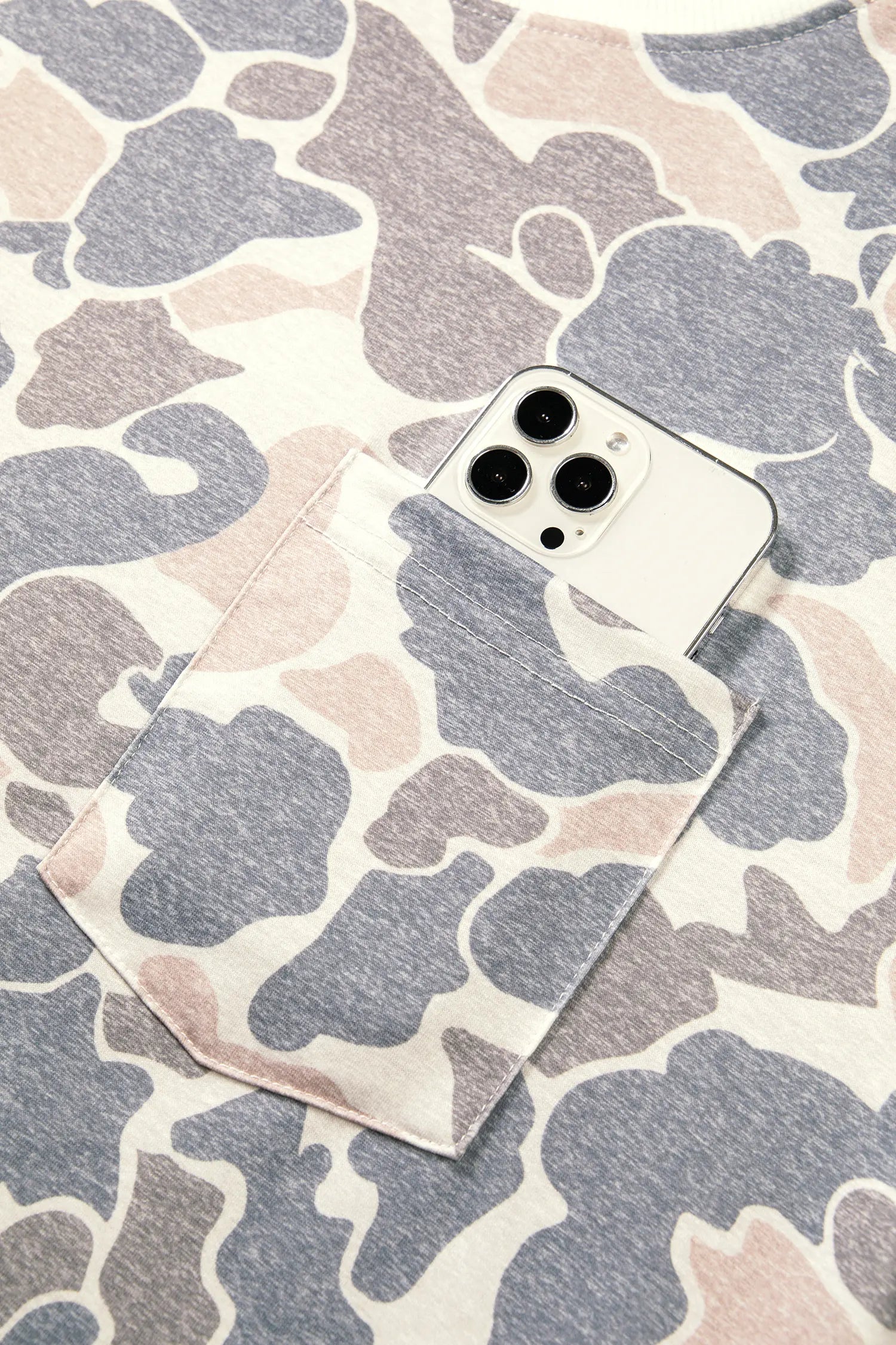 Chest pocket holding a phone on the beige camo print dress
