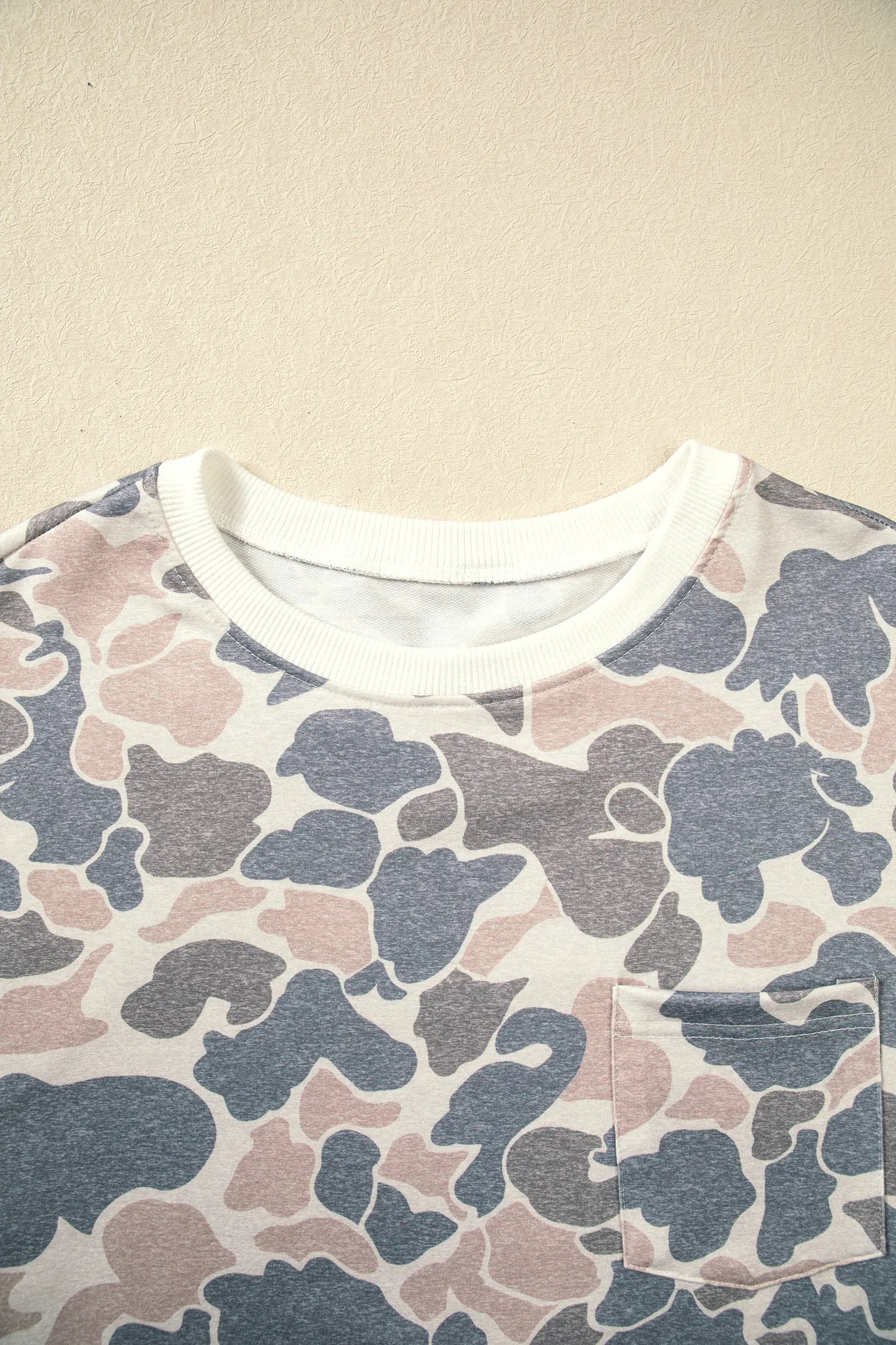 White ribbed neckline and chest pocket on the beige camo dress