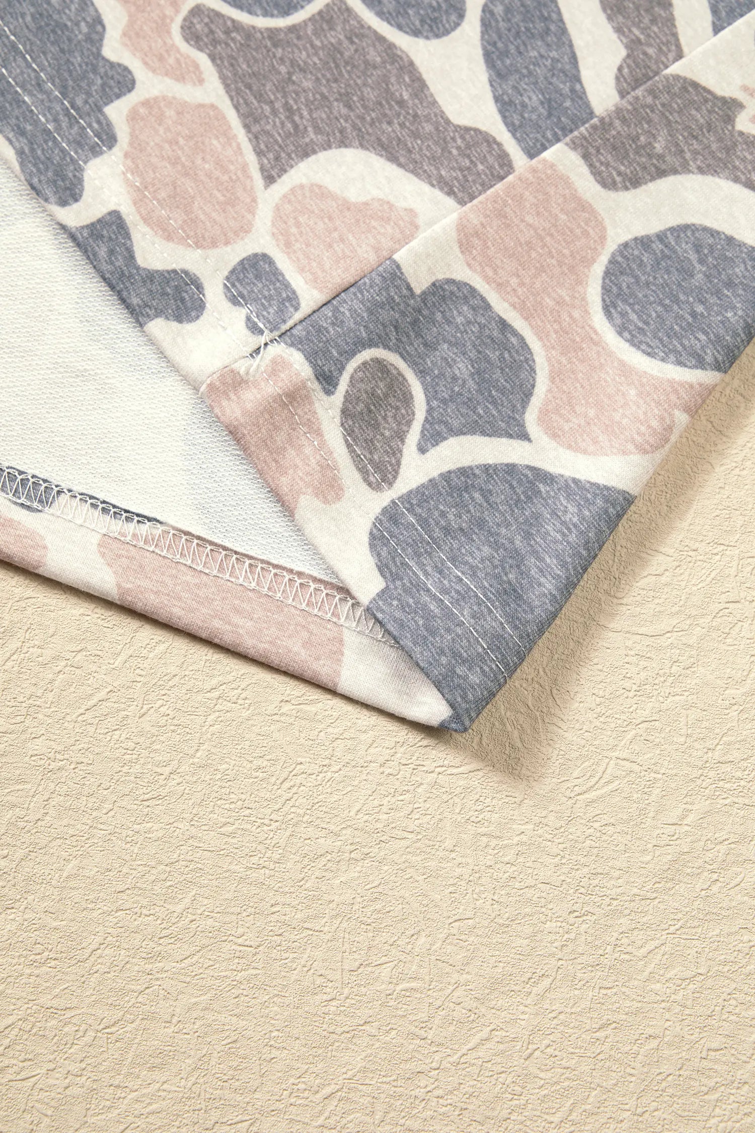 Folded hem and side seam on the beige camo dress