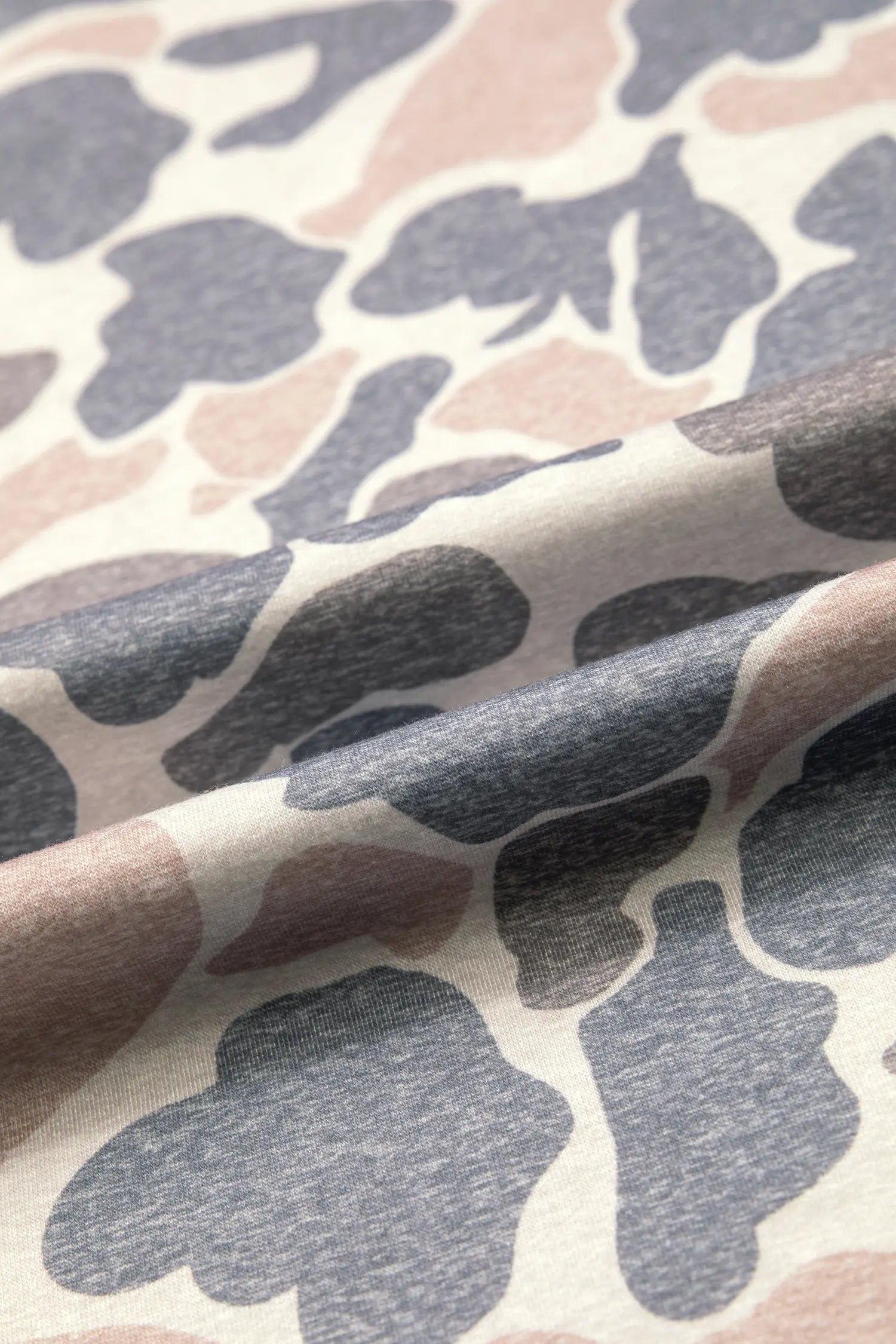 Close up of soft camo print knit in gray, taupe and dusty pink