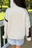 Back view of beige mock neck sweater with brown cow spot sleeve patches