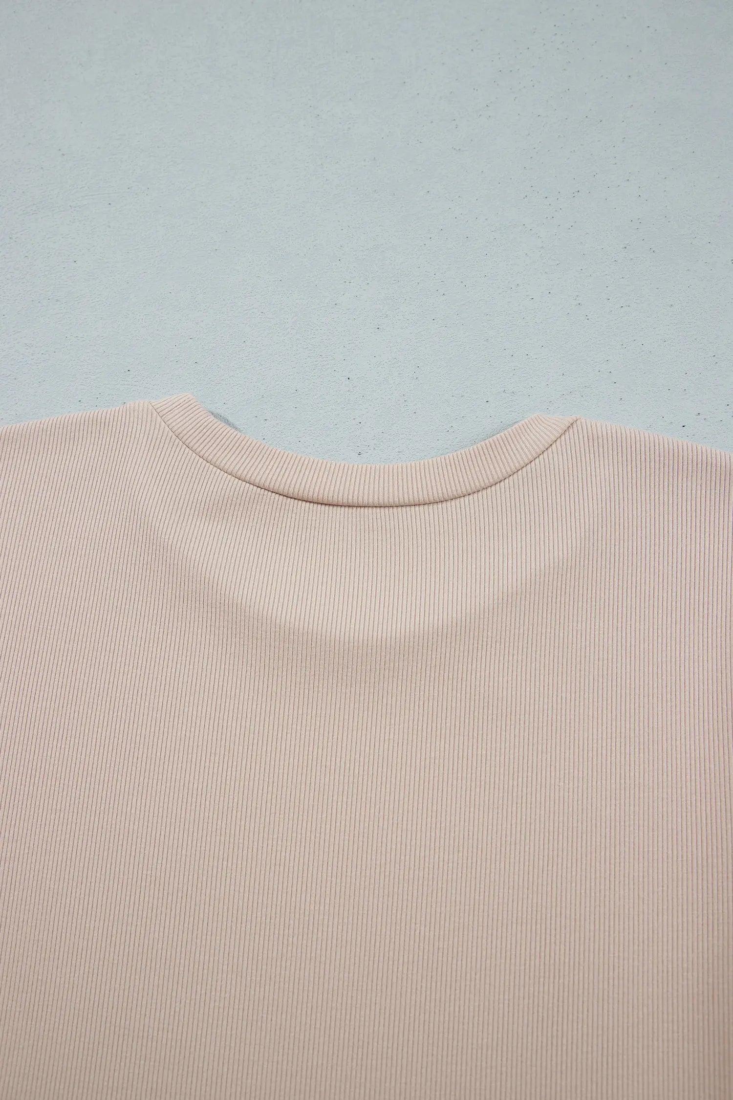 Back neckline detail on beige ribbed knit dress