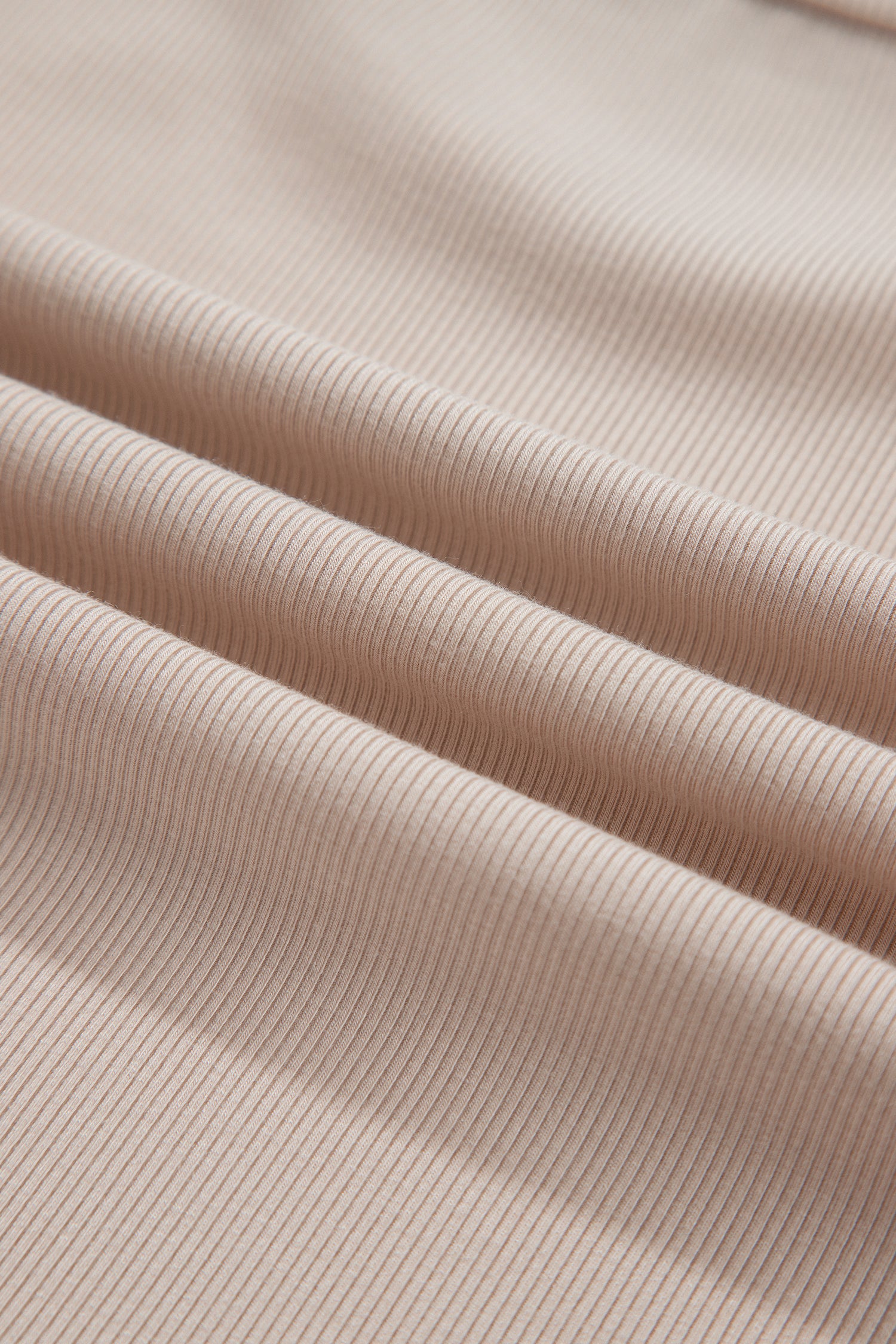 Close-up of soft beige ribbed knit fabric