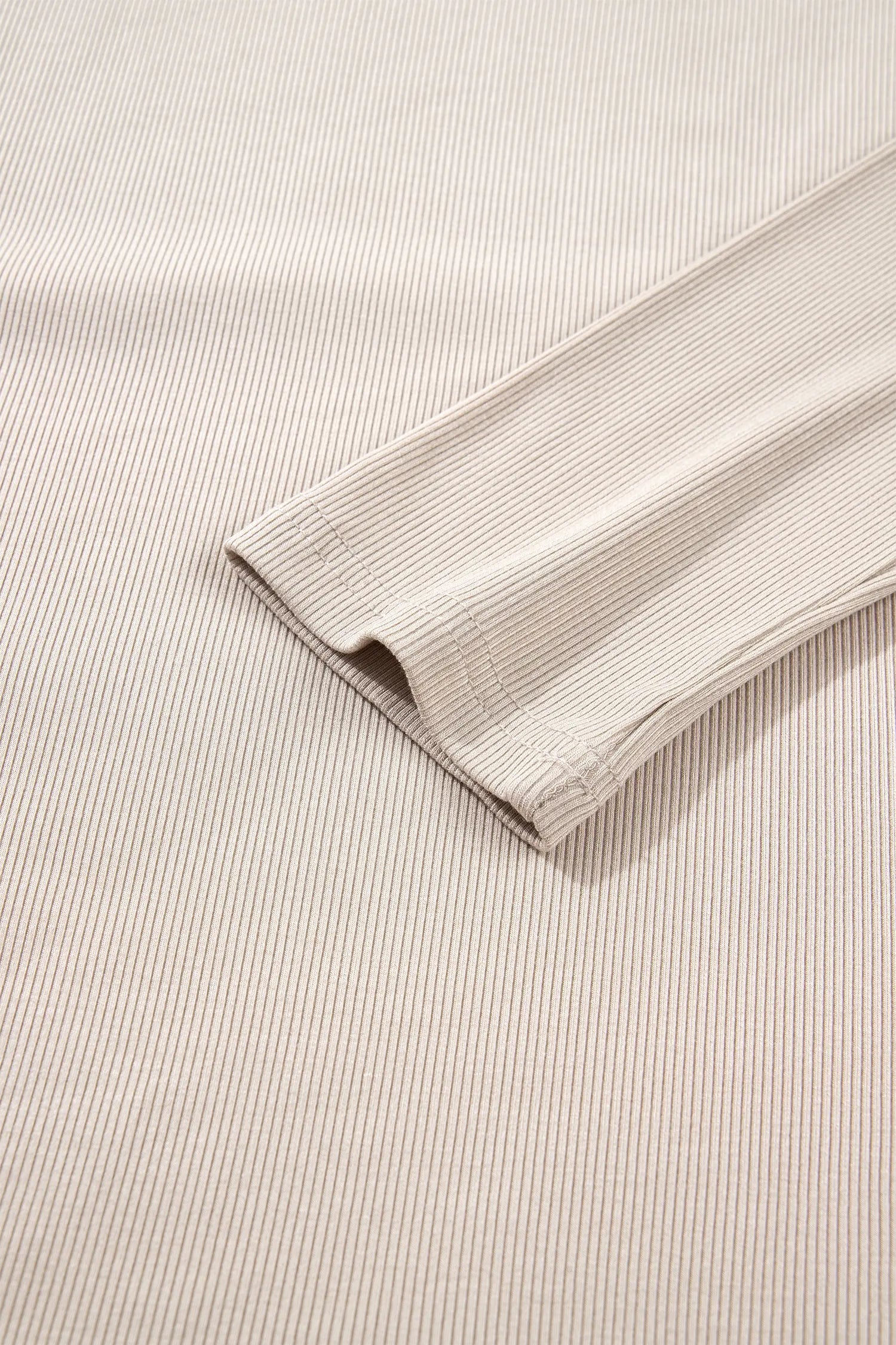 Close-up of cuff on beige ribbed long sleeve top
