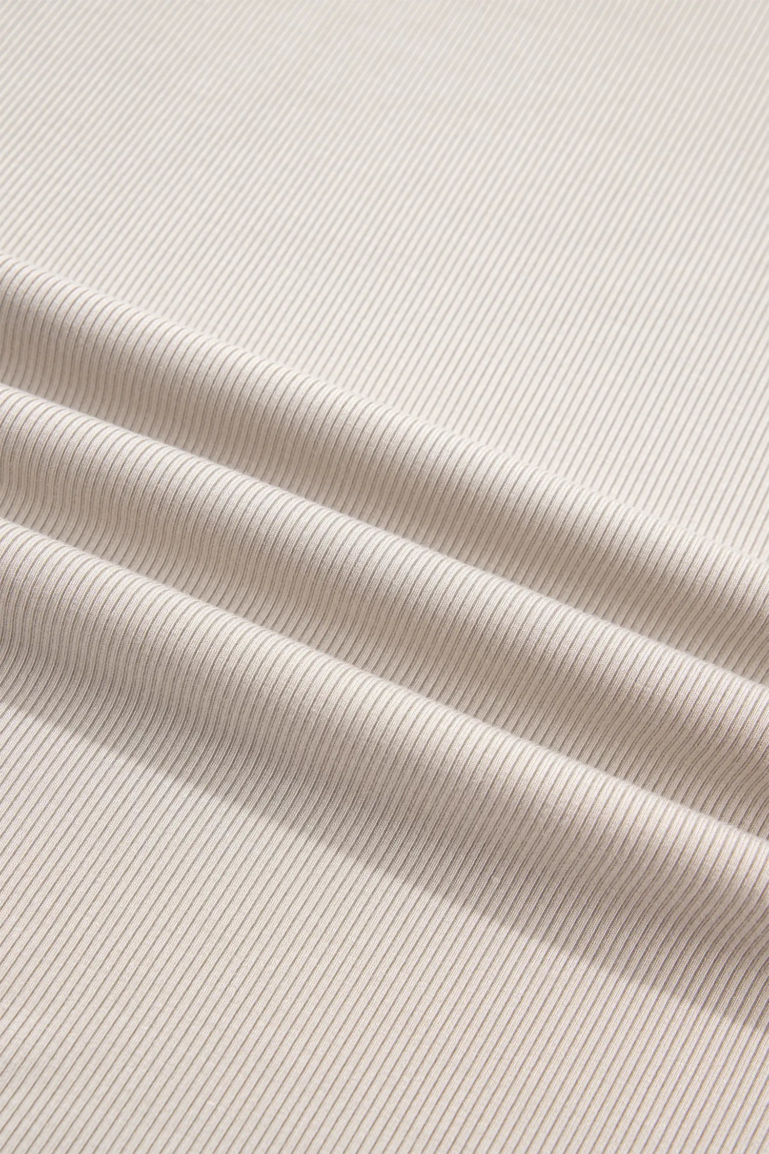 Close-up of soft beige ribbed knit fabric