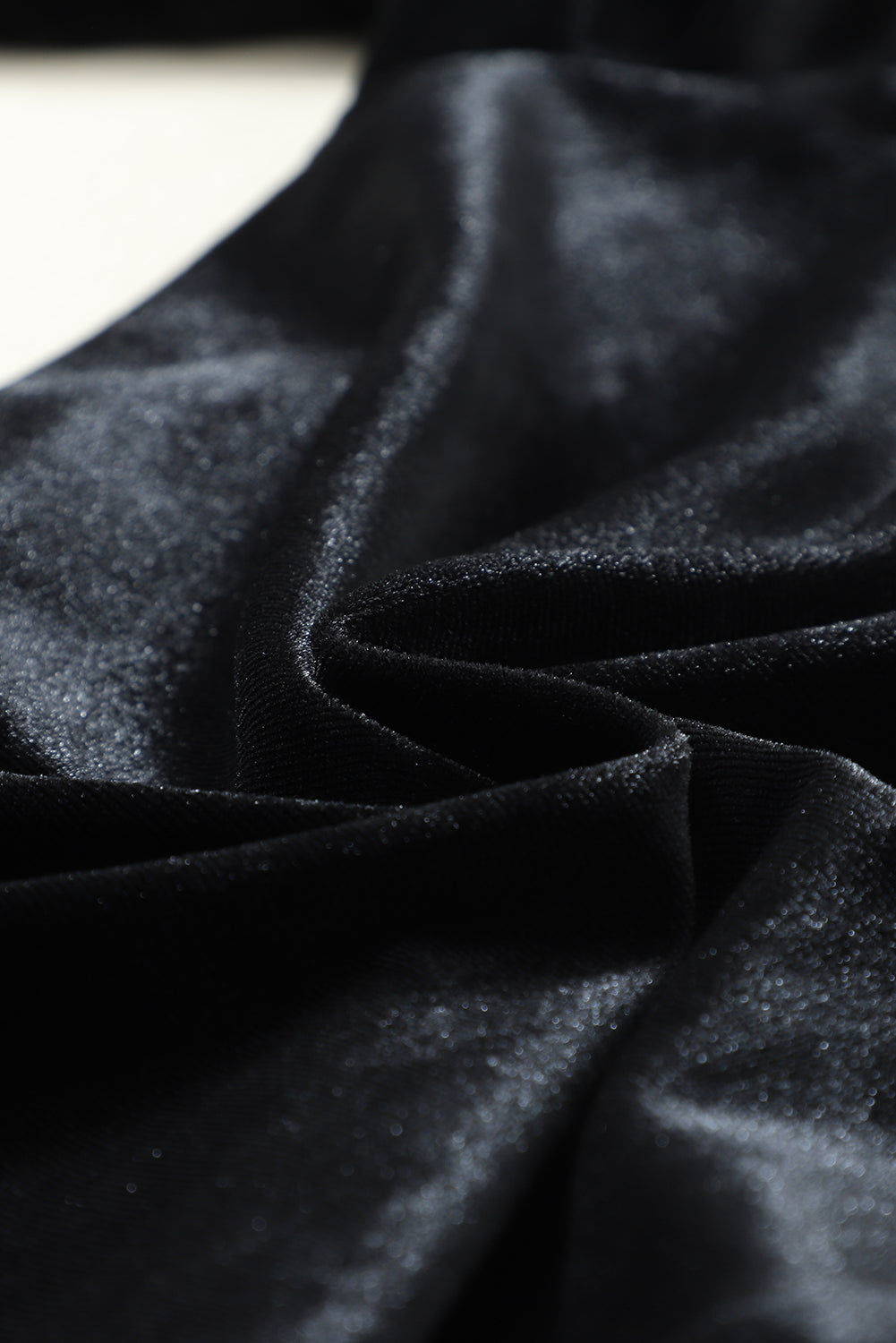 Close-up of soft black stretch velvet fabric with a subtle sheen