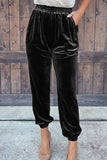 Black velvet high waist jogger pants with elastic cuffs and nude heels, front view