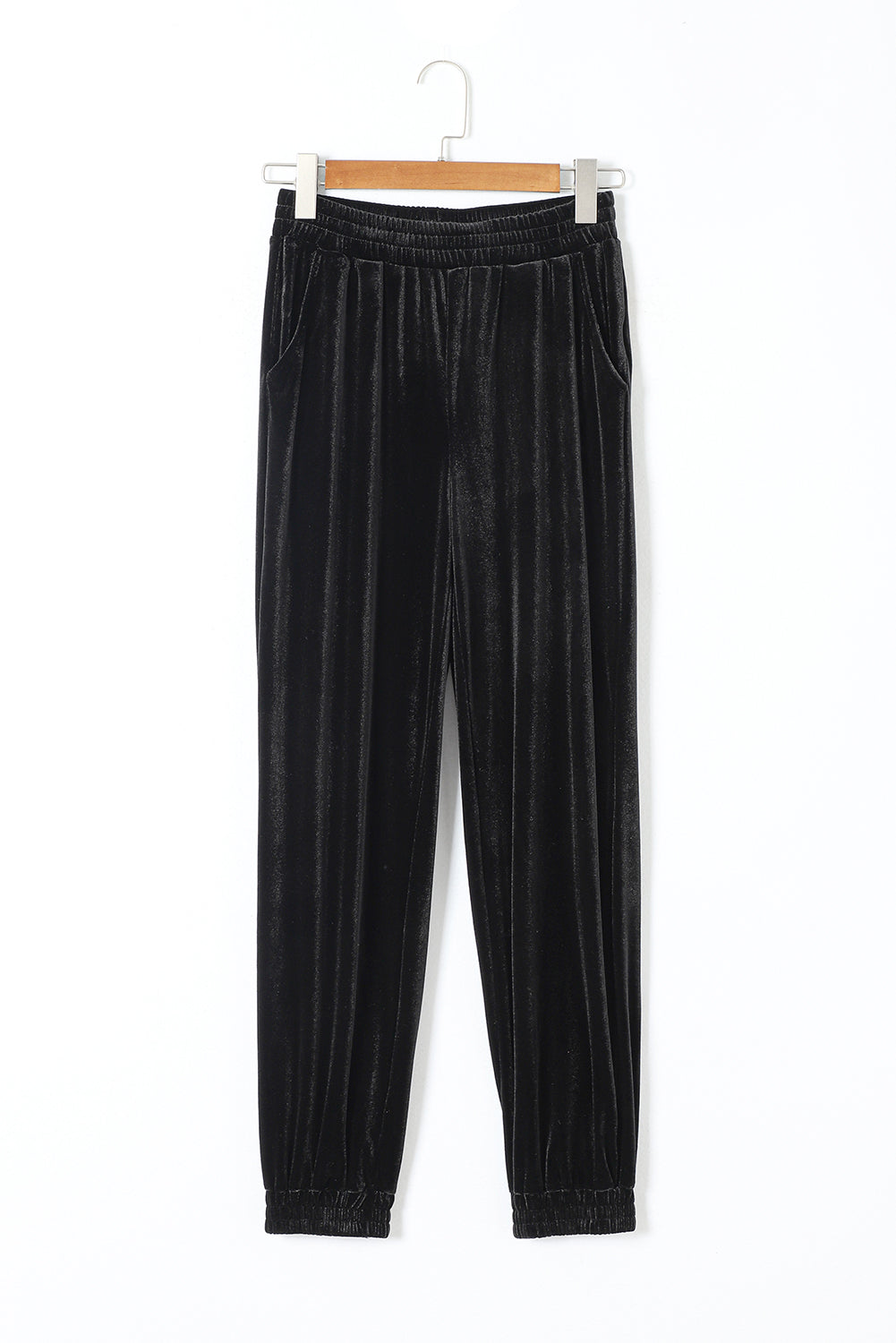 Black velvet jogger pants on a hanger, back view