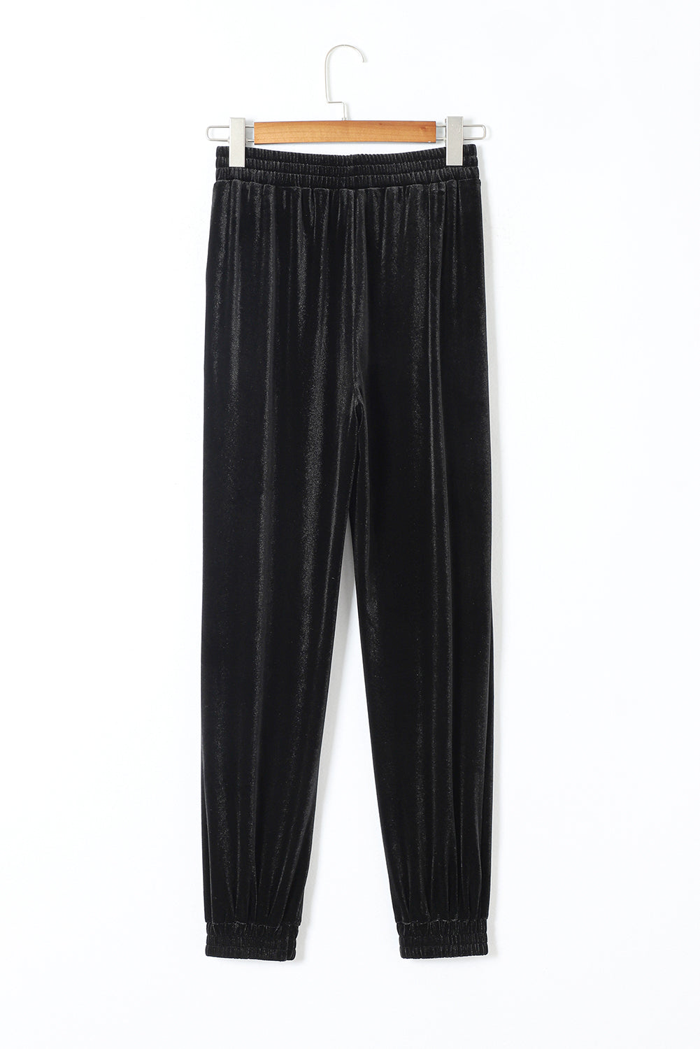 Black velvet elastic waist jogger pants on a hanger, front view
