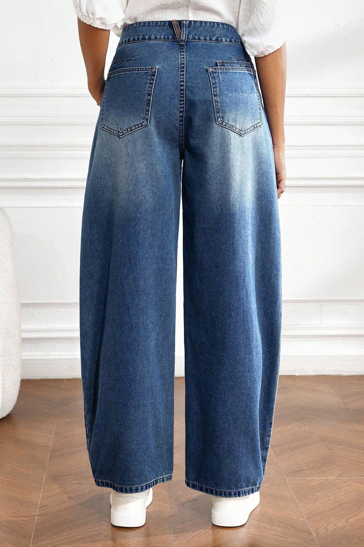 Back view of medium wash barrel leg jeans with back patch pockets