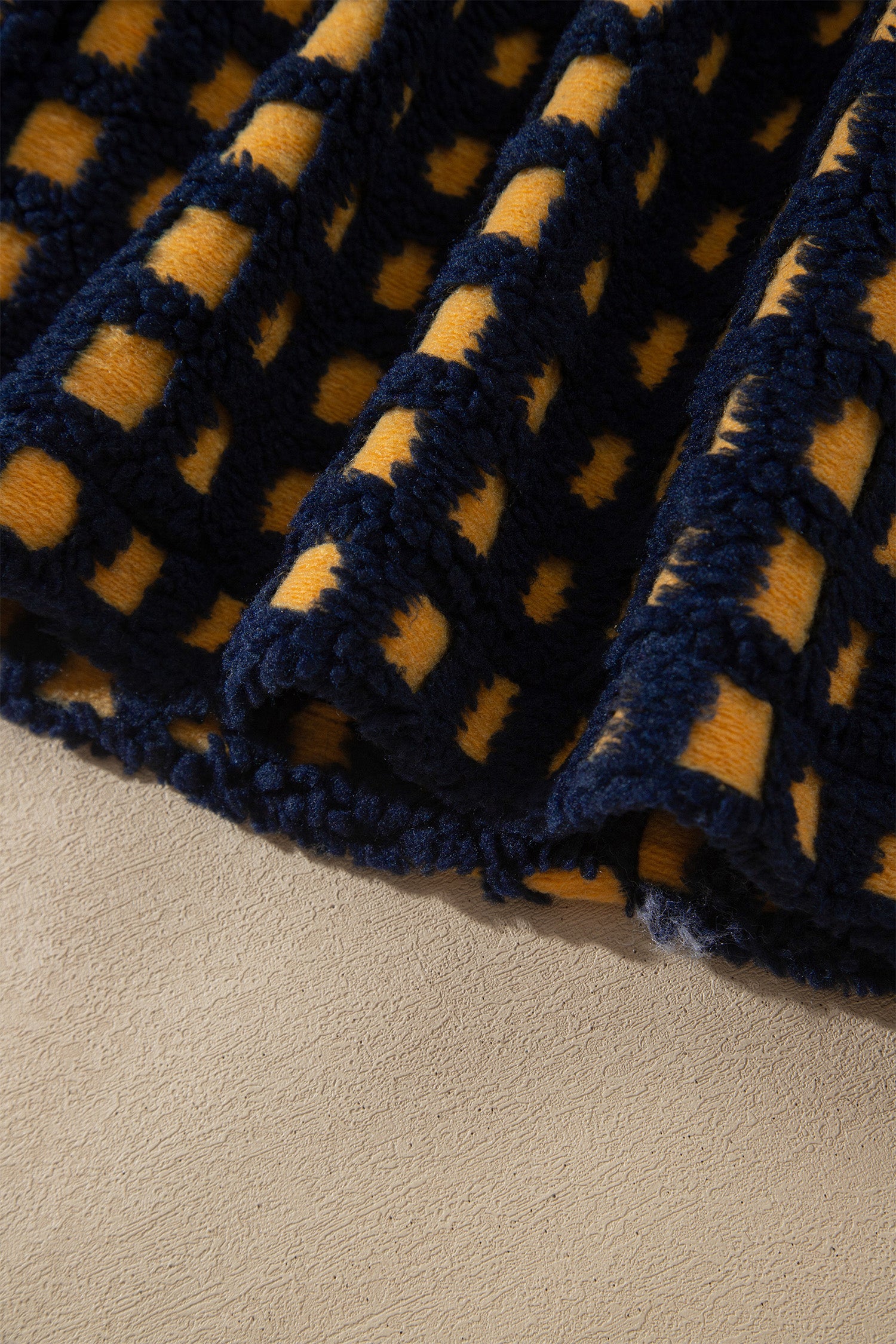 Elastic hem detail on navy and mustard check sherpa fleece jacket