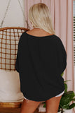Person wearing a black oversized top and white shorts in a casual setting.