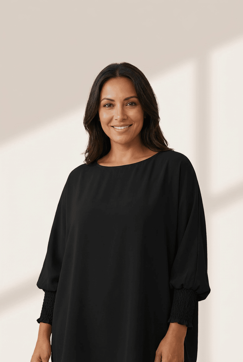 Woman wearing a black dress against a neutral background