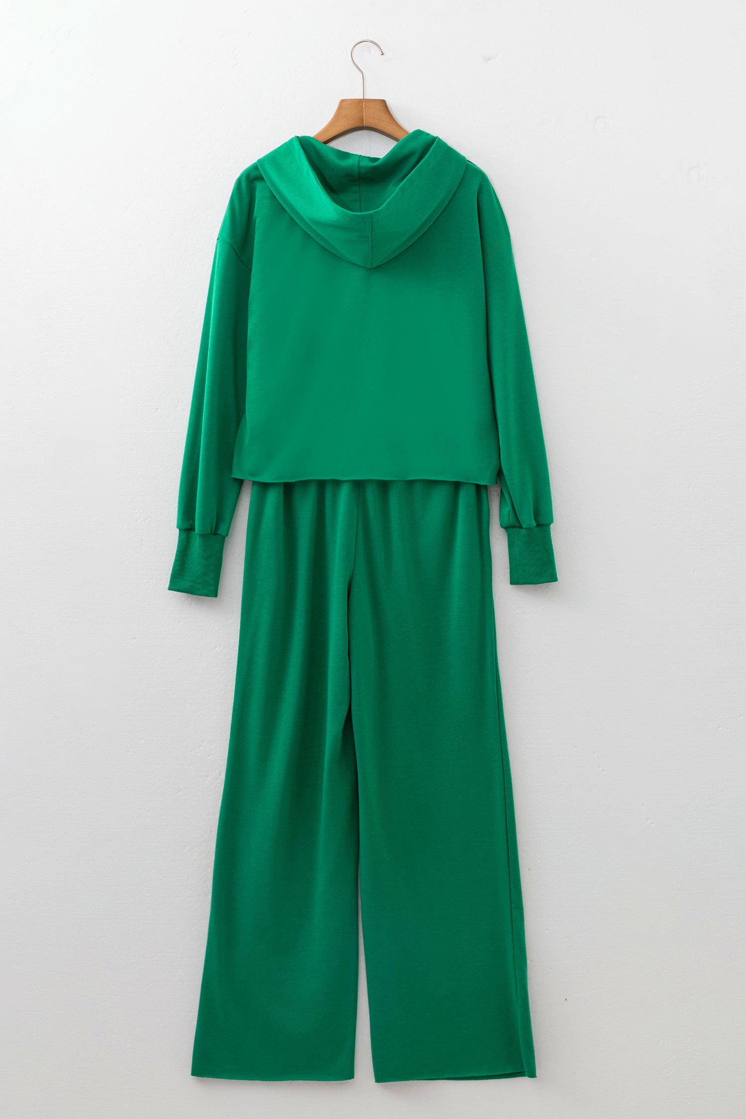 Bright green hoodie and wide leg pants set on a hanger, back view