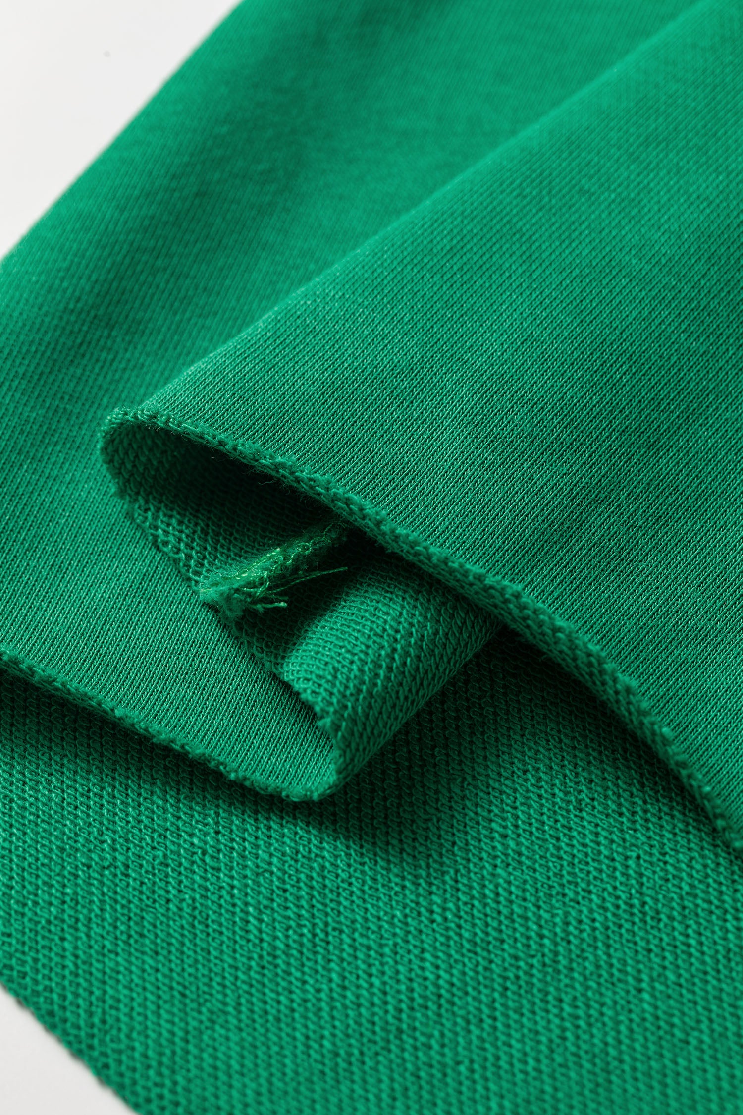 Folded bright green cotton blend fabric showing soft texture