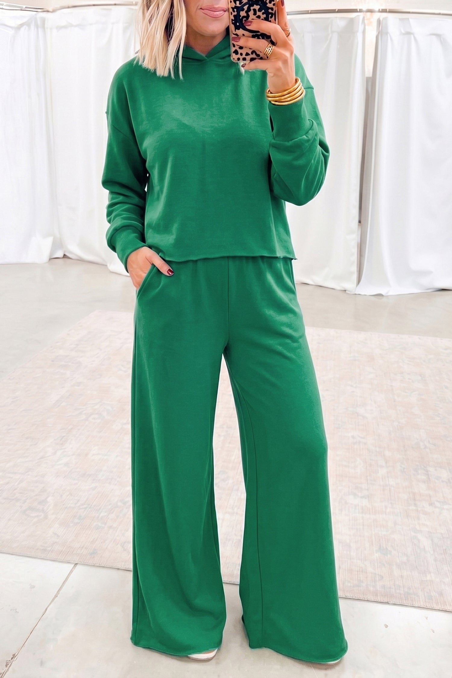 Woman in bright green cropped hoodie and wide leg pants set, mirror selfie