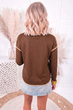 Back view of brown pin dot long sleeve shift top with tan trim on shoulders and curved hem