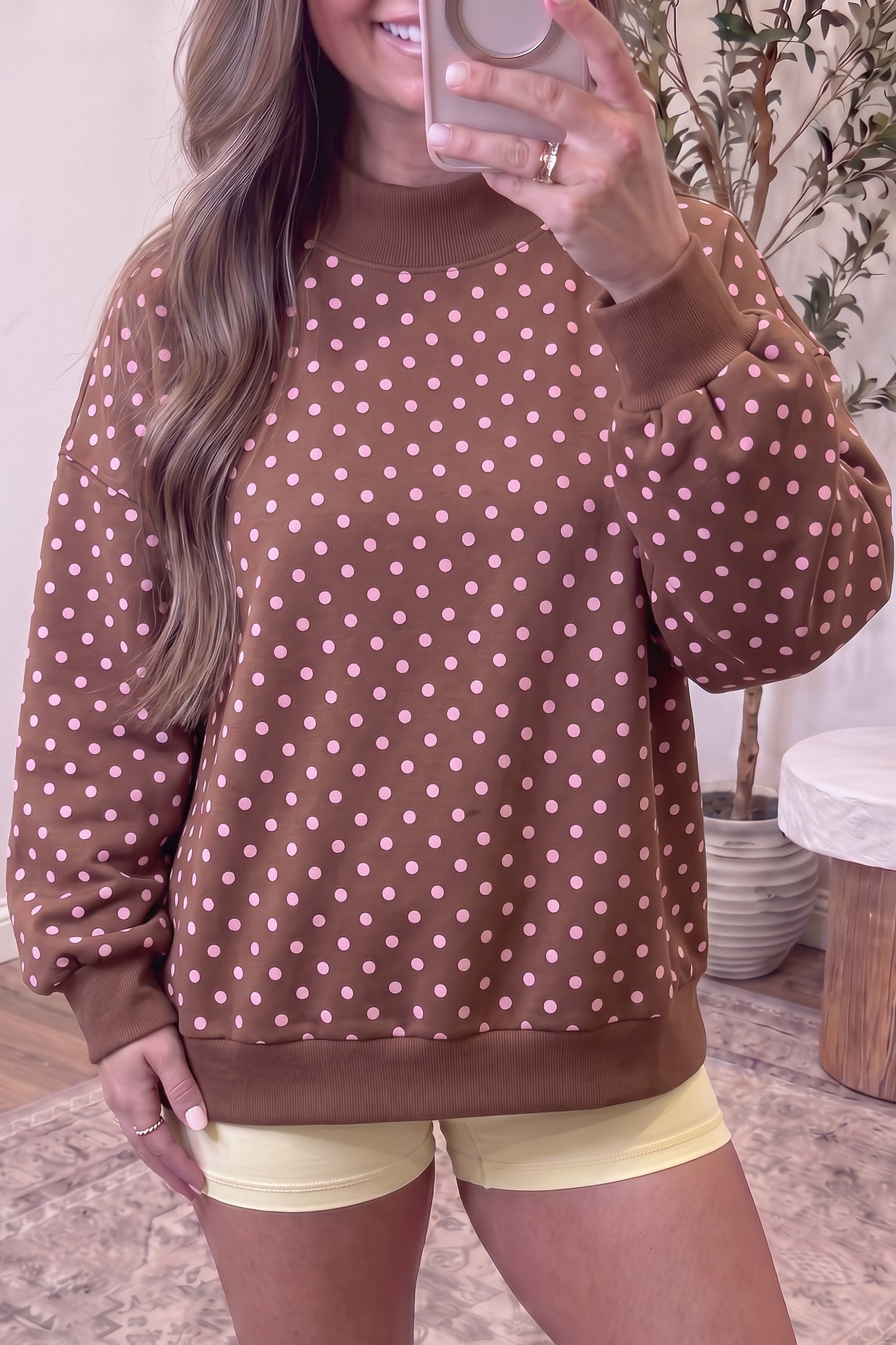 Brown polka dot mock neck sweatshirt with white dots and balloon sleeves, front view