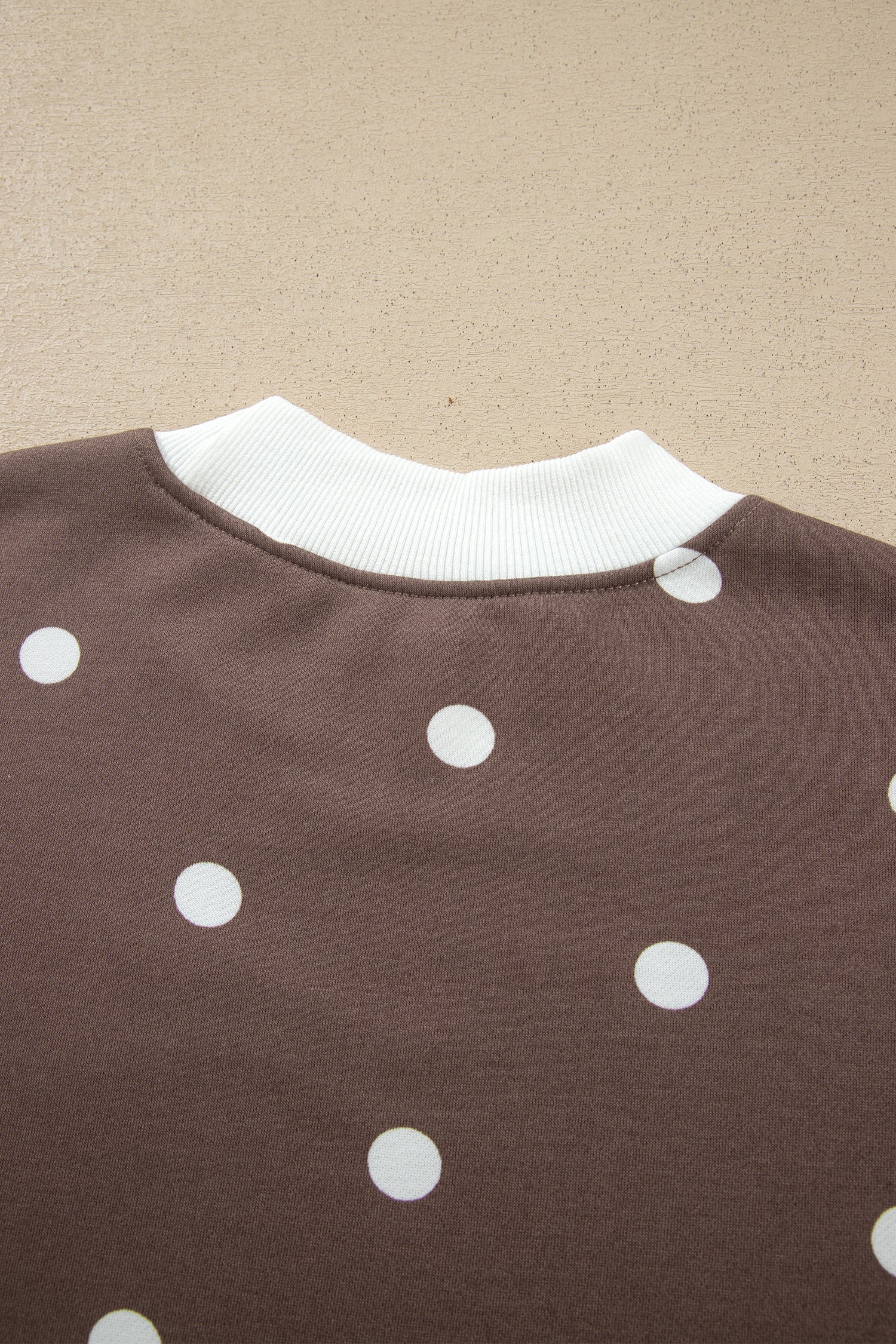 Back ribbed neckline detail on brown polka dot top