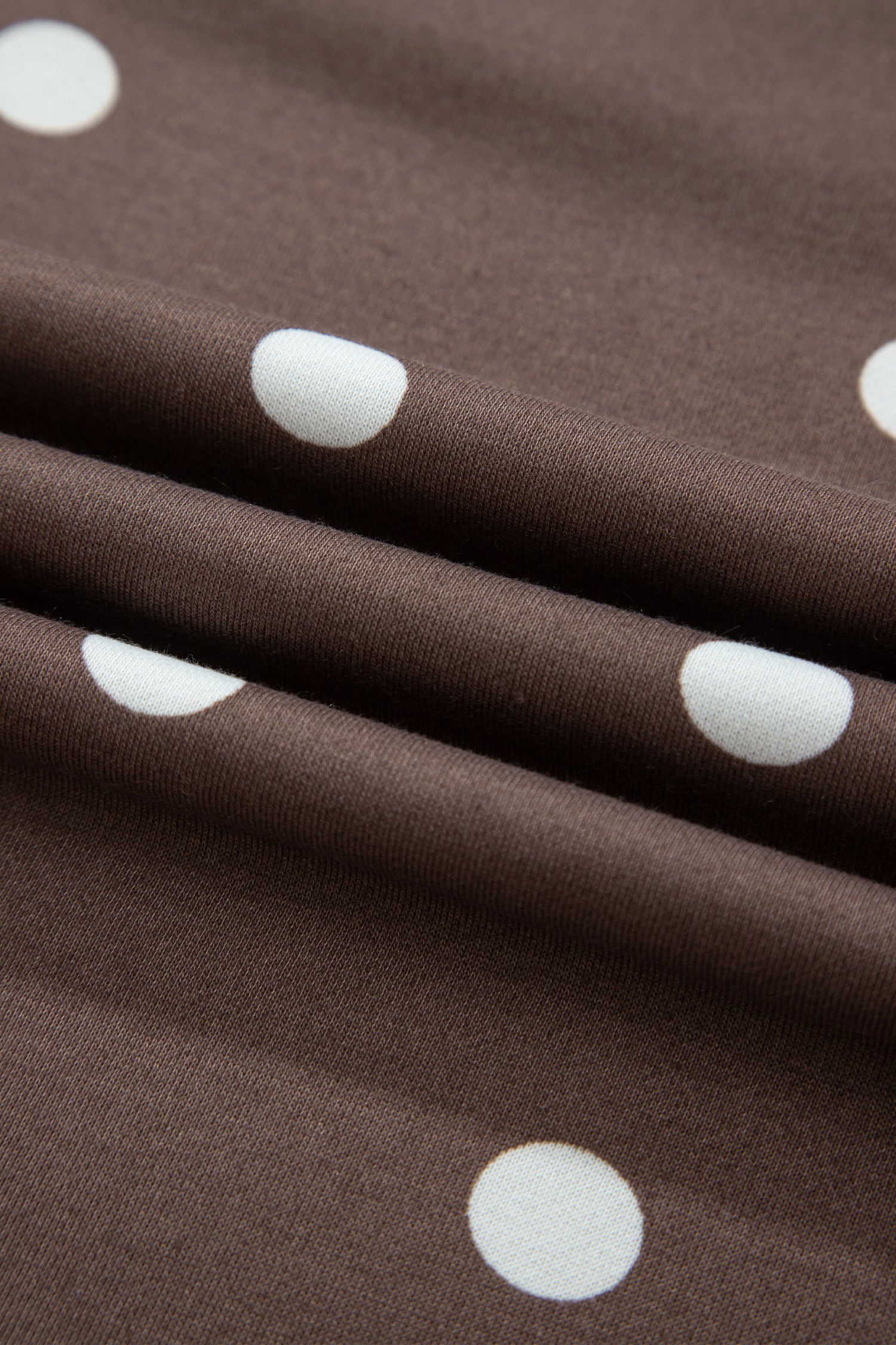 Polka dot print fabric texture on brown set, close-up