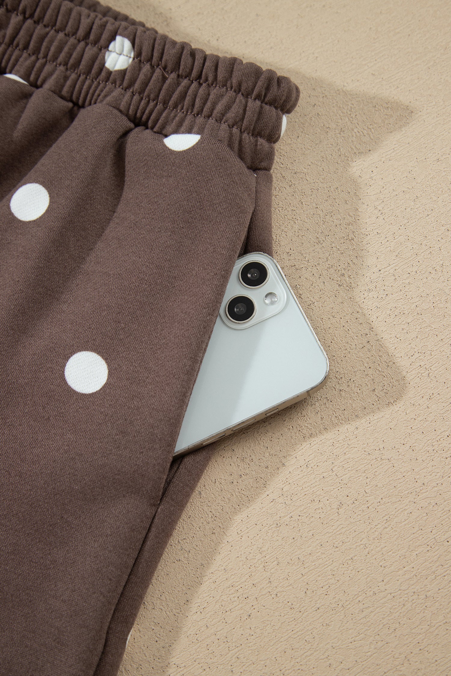 Side pocket holding a phone on brown polka dot shorts